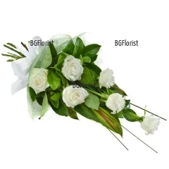 Classic bouquet of six white roses and greenery, gently arranged with wrapping paper, tied with a ribbon