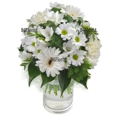 Букет от бели миксови цветя - гербери, хризантеми, карамфили, алстромерии и зеленина, привързан с панделка.
