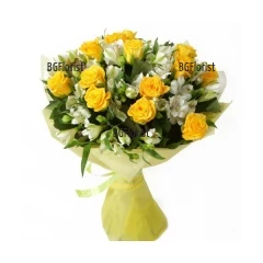 Слънчев букет от жълти рози, бели алстромерии и обилна свежа зеленина, обвит с подходяща опаковка.