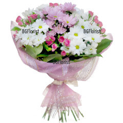 Loving bouquet of mixed flowers in pink and white hues - pink spray roses, white and pink chrysanthemums, wrapped in gift paper.
