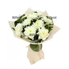 Bouquet of white chrysanthemums and greenery, complemented by dry elements and effective gift .