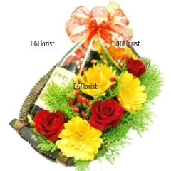 A basket, arranged with yellow gerberas, red roses, greenery and a bottle of red wine Mezzek. Perfecf gift for festive  occasions .