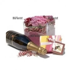 Splendid gift for the beloved one - arrangement with pink roses in glass cube, a bottle of Champagne and luxury chocolates