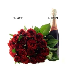 Стилен букет от червени рози, привързан с панделка, допълнен с бутилка шампанско.