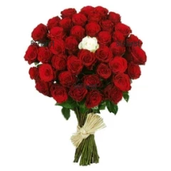 Стилен, чувствен букет от червени рози и една бяла роза в средата, привързан с рафия.
