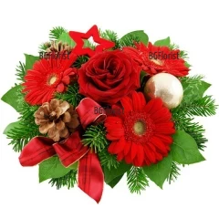 Romantic, festive bouquet of flowers in red hues, arranged with Christmas greenery and decorations.