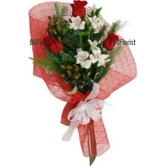 Класически букет от бели и червени цветя - алстромерии и рози, аранжирани с обилна коледна зеленина.
