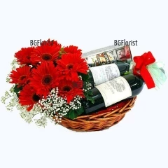 Exquisite gift for special recipients - relatives or friends. Amazing basket with gifts - two bottles of red and white wine -brand Mezzek,  a bottle of Chivas Regal whisky and flowers - beautiful arrangement on piaflora of red gerberas and greenery