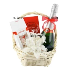 A gift basket with decoration, perfect gift for the holidays - The Christmas and the New Year. Combination of  delicious chocolates and sparkling wine.